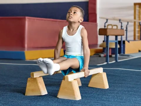 a boy sitting on wooden blocks