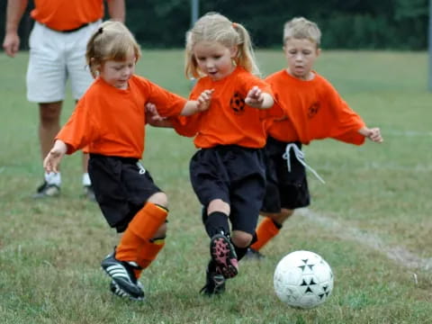 kids chasing a football ball