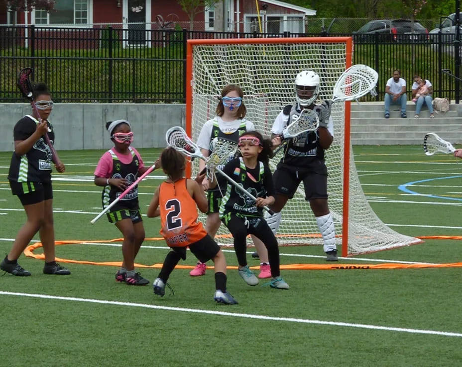 a group of people playing lacrosse