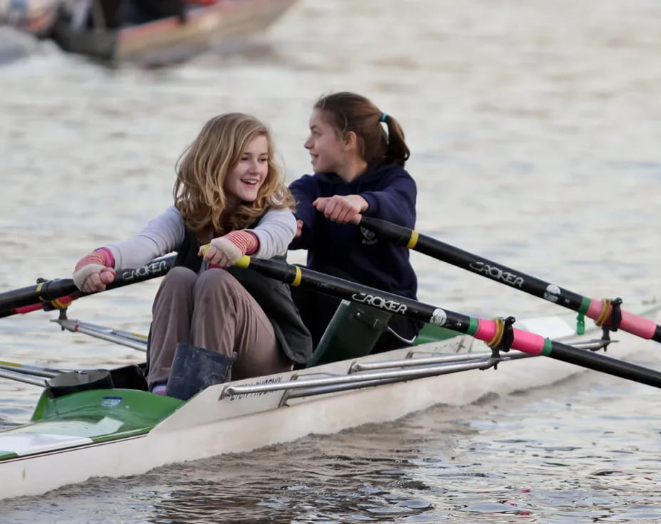 a group of girls rowing a boat