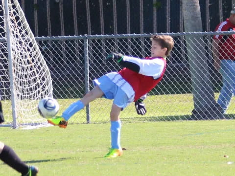 a boy kicking a football ball