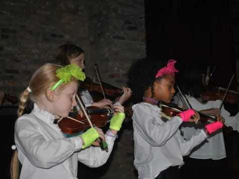 a group of girls playing violin