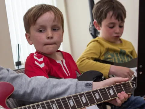 a couple of boys playing a guitar