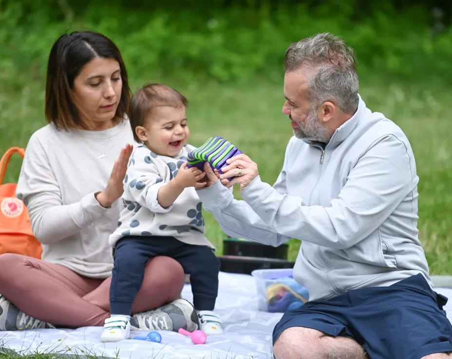 a man and woman holding a baby