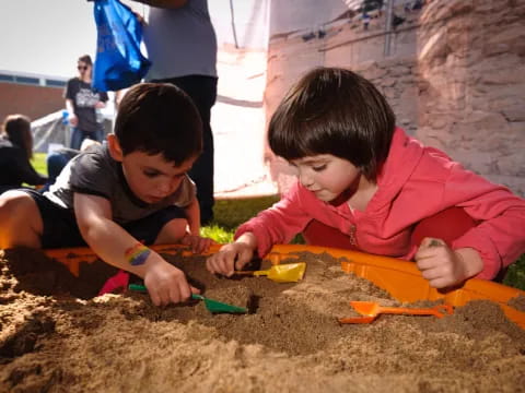 a couple of boys playing in sand