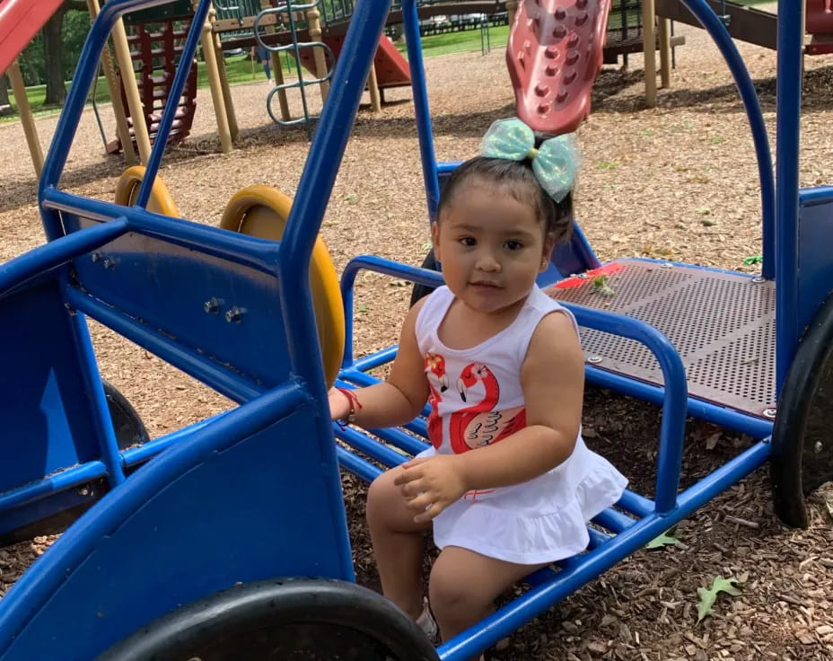 a child sitting in a playground toy