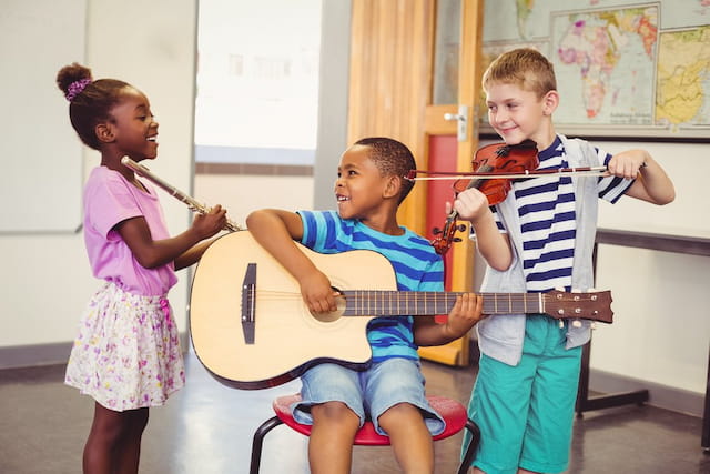 a group of children playing a guitar
