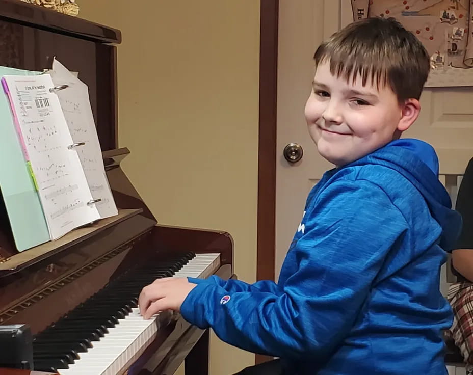 a boy playing a piano