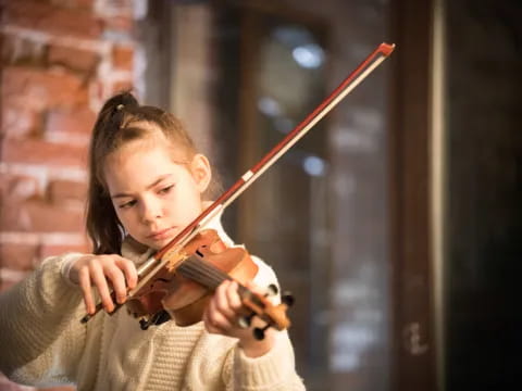 a young girl playing a violin