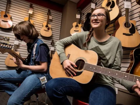 a woman and a boy playing guitars