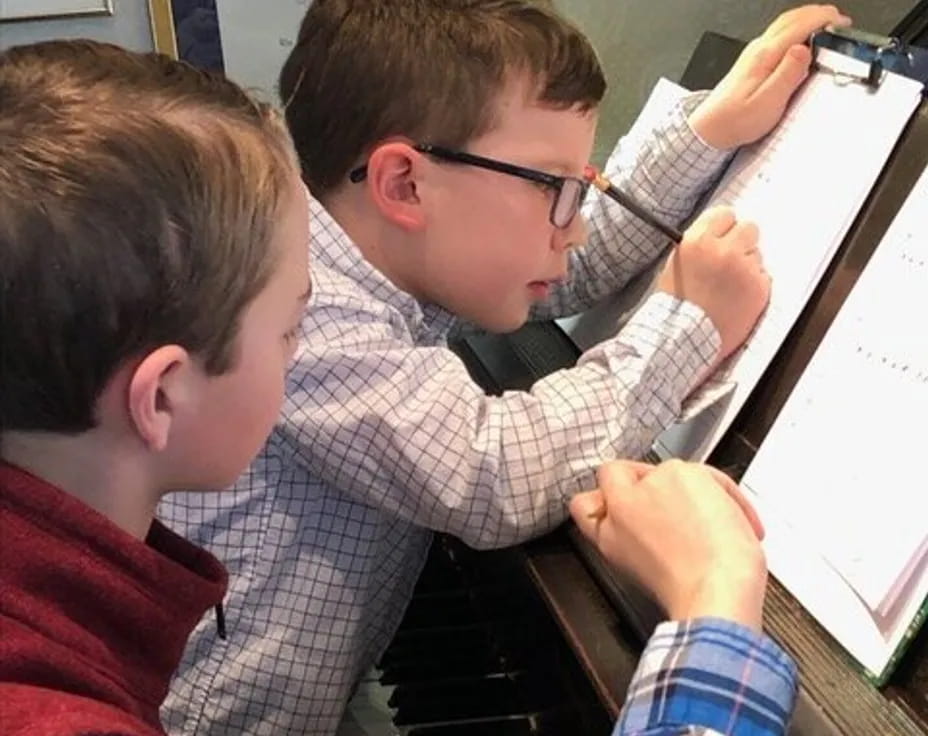 a group of boys playing piano