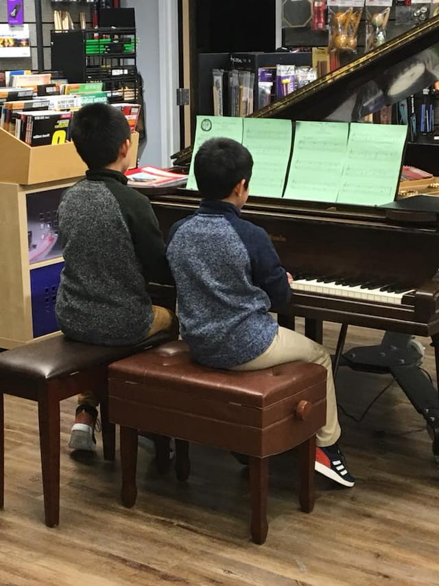 a couple of kids playing piano