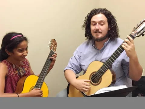 a man and a woman playing guitars