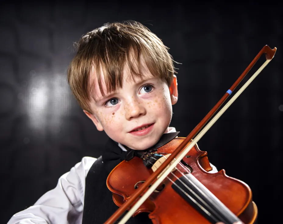 a boy holding a violin