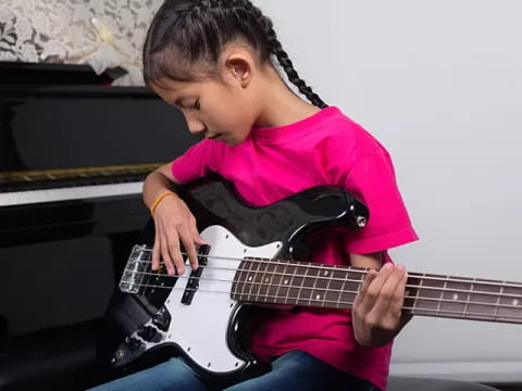 a young girl playing a guitar