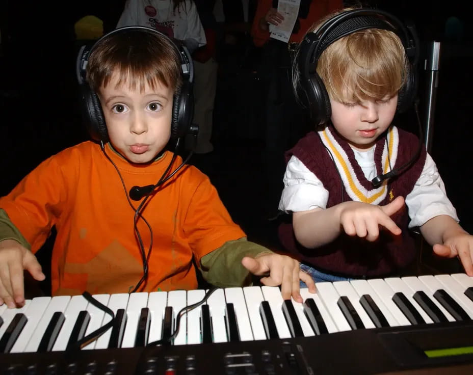 two children playing a piano