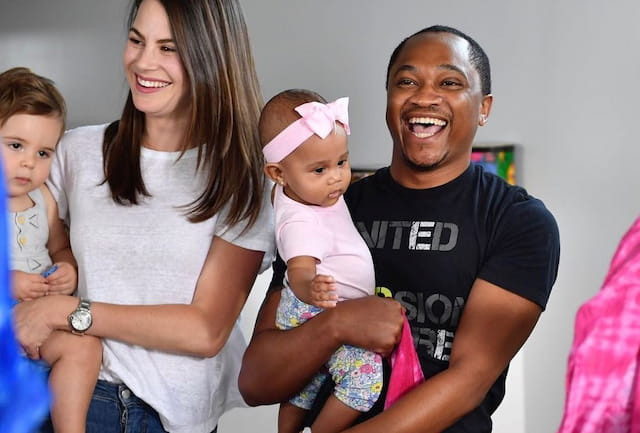 a man and woman holding a baby