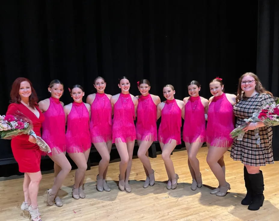 a group of women in pink dresses