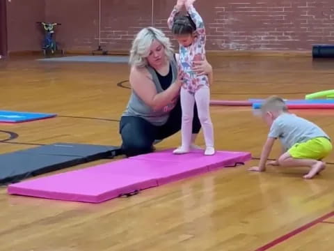 a woman and two children on mats