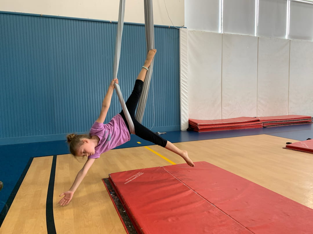a boy doing a handstand on a mat