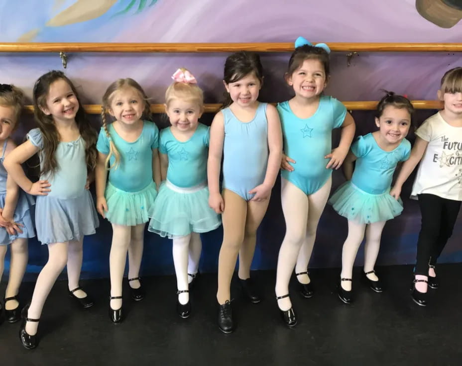 a group of girls in blue dresses