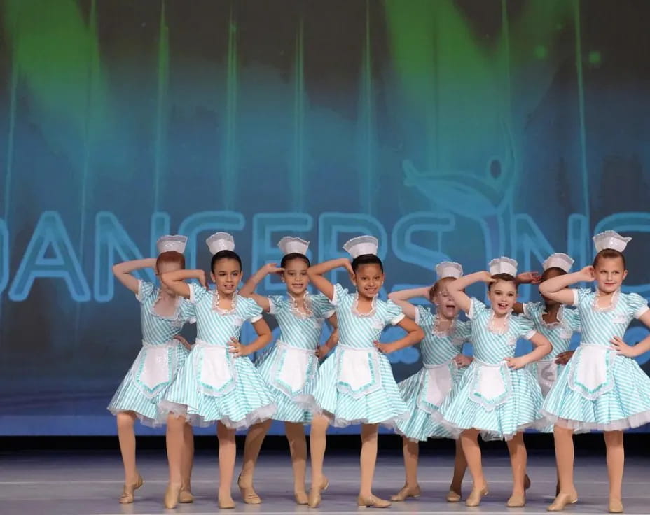 a group of girls in blue dresses