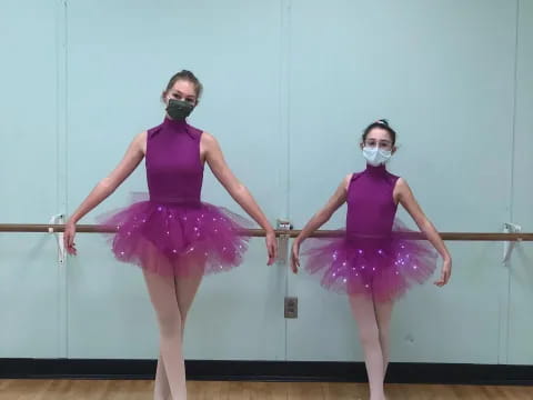 two women in purple dresses