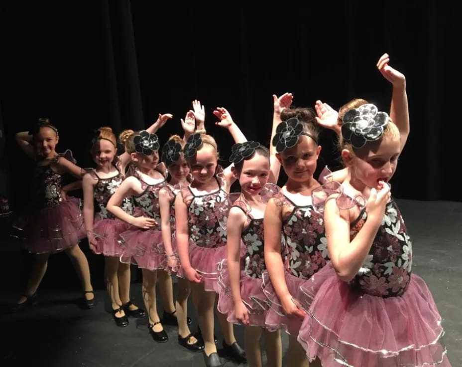a group of girls in dresses dancing