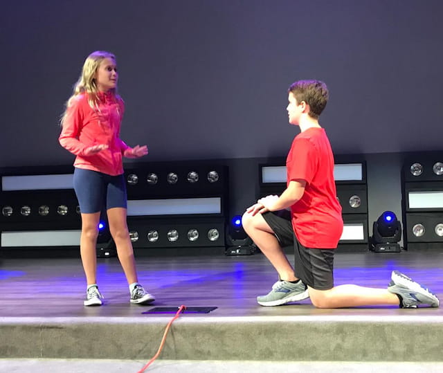 a man and a woman playing a game on a stage