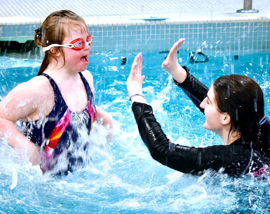 a person and a girl in a pool