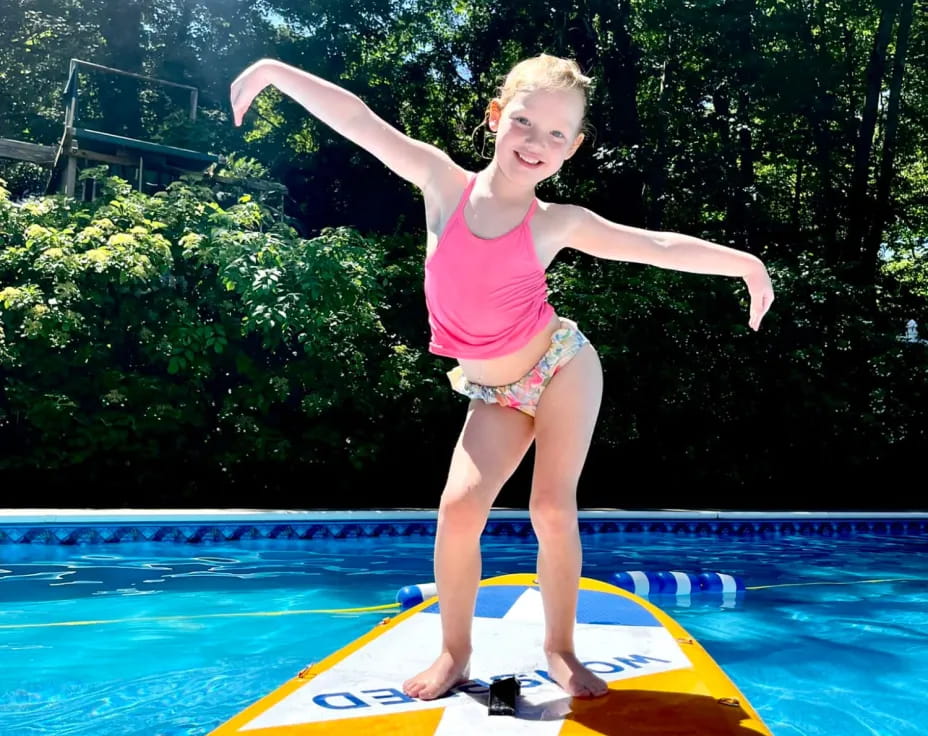 a girl jumping into a pool