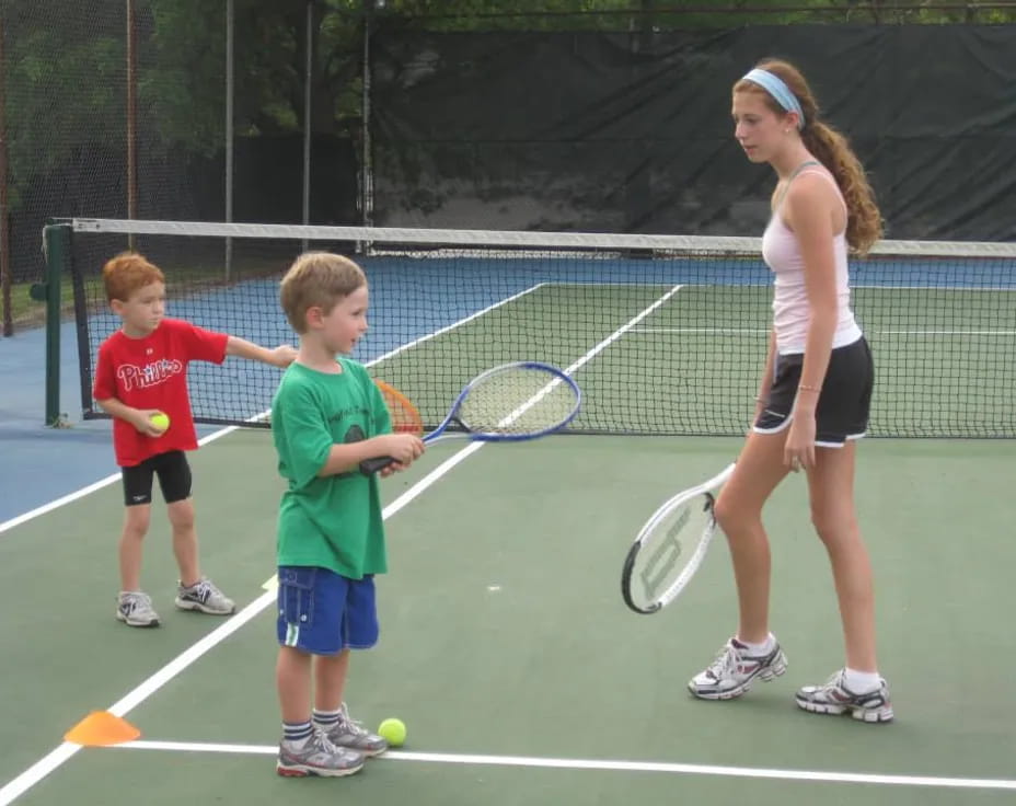 a person and kids playing tennis