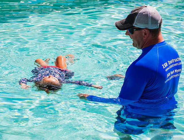 a person in a pool with a person in the water