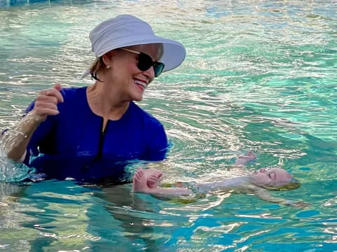 a person in a pool with a dolphin