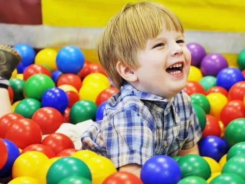a boy in a ball pit