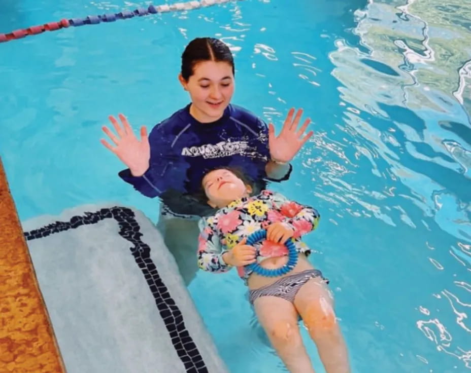 a person and a baby in a pool