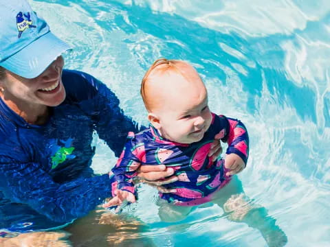 a man holding a baby in a pool