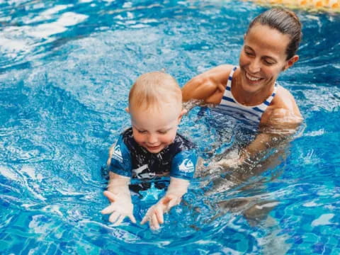 a person and a baby in a pool