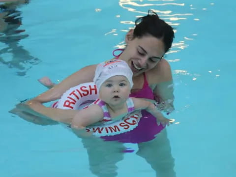 a person and a baby in a pool