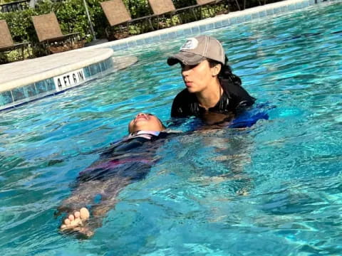 a man holding a baby in a pool