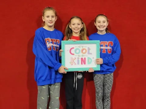 a group of girls holding a sign