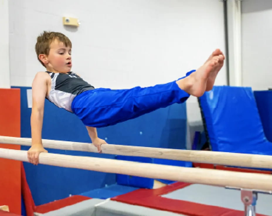a boy doing a handstand on a bar
