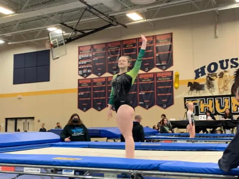 a person jumping over a blue mat