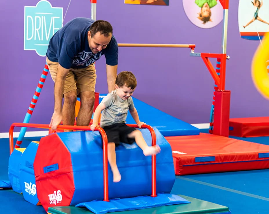 a person and a boy playing on a toy