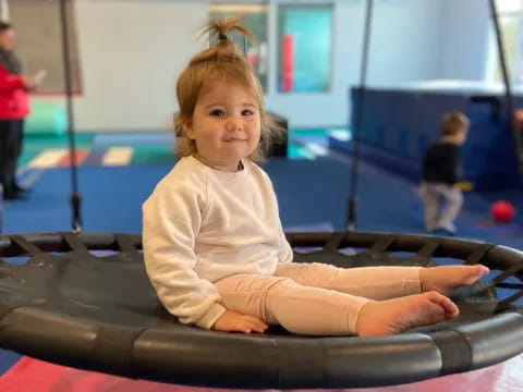 a girl sitting on a trampoline