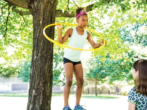 a girl holding a yellow hoop
