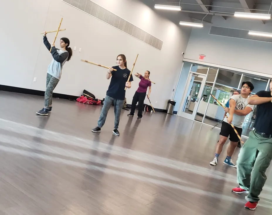 a group of people holding sticks