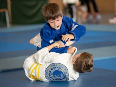 a couple of boys playing on a mat
