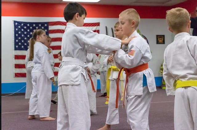 a group of children in karate uniforms
