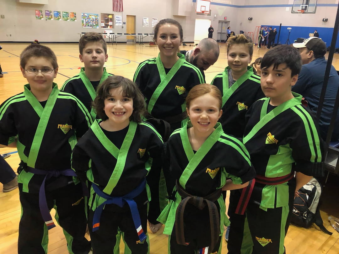 a group of children in green and black uniforms